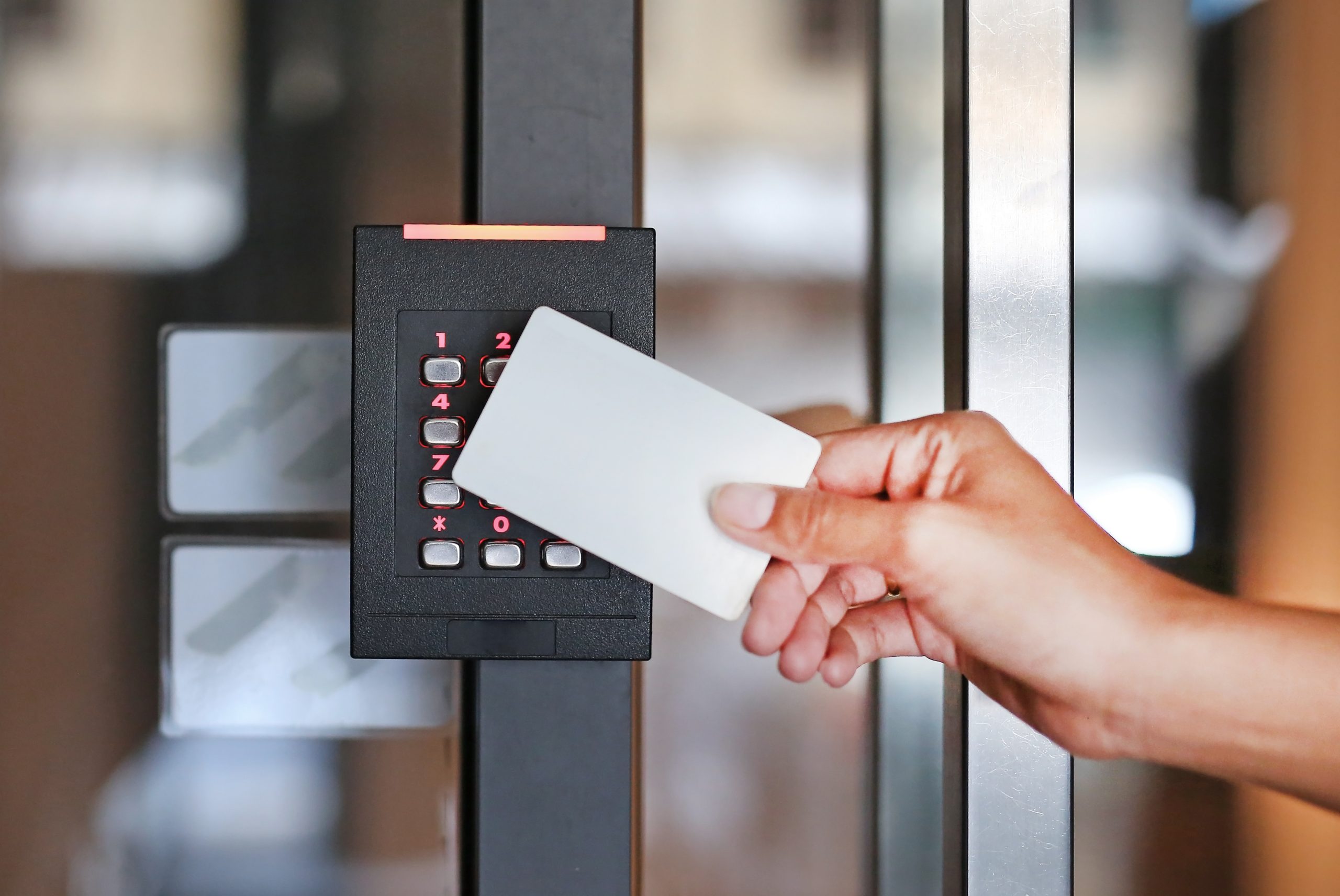 Door access control - young woman holding a key card to lock and